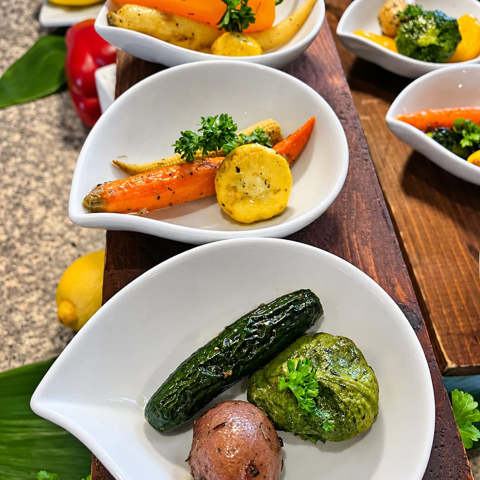Individual white bowls of colorful vegetables arranged on a wooden display