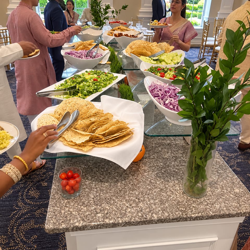 Guests serving themselves from a salad and papad buffet