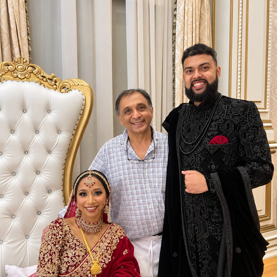 Three guests posing beside gold and white wedding seating