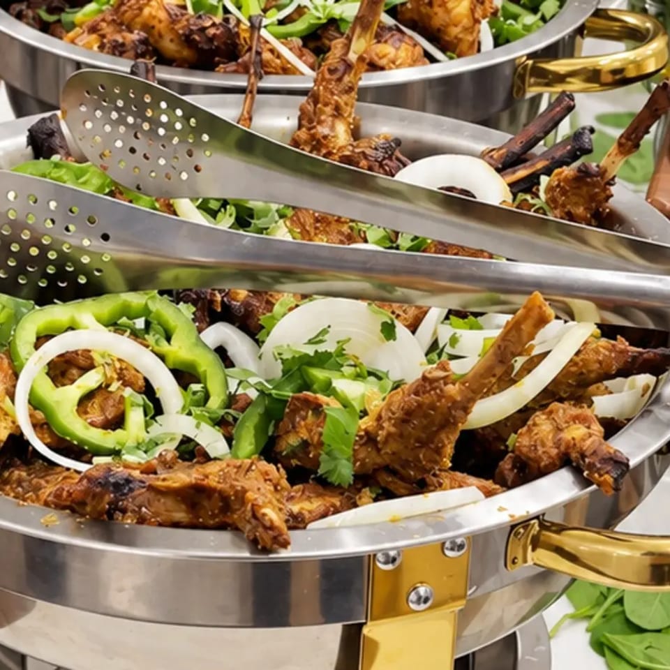 Grilled chops arranged with onions and peppers at a catered event