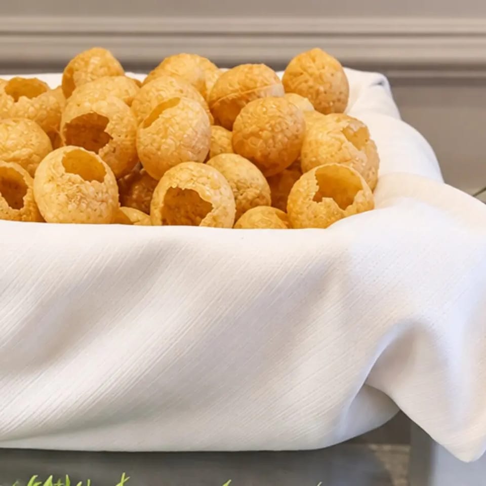Crisp pani puri shells displayed in a linen-lined basket