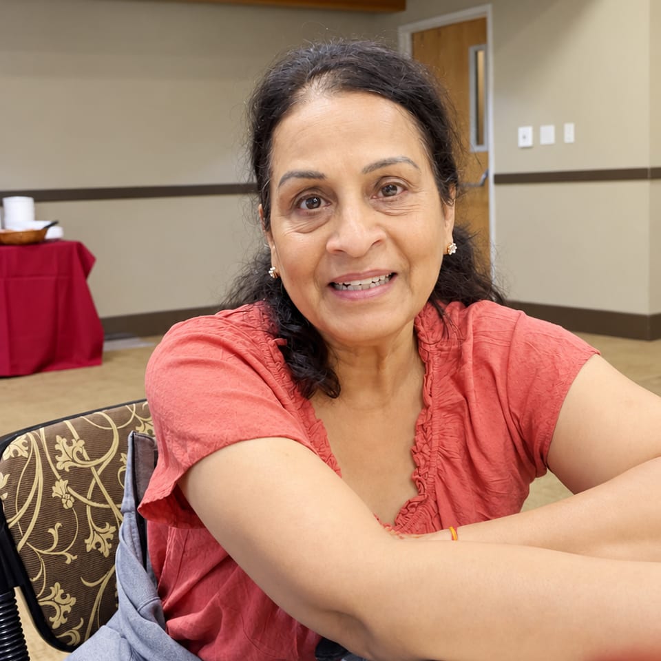 Guest in a coral blouse seated at a table