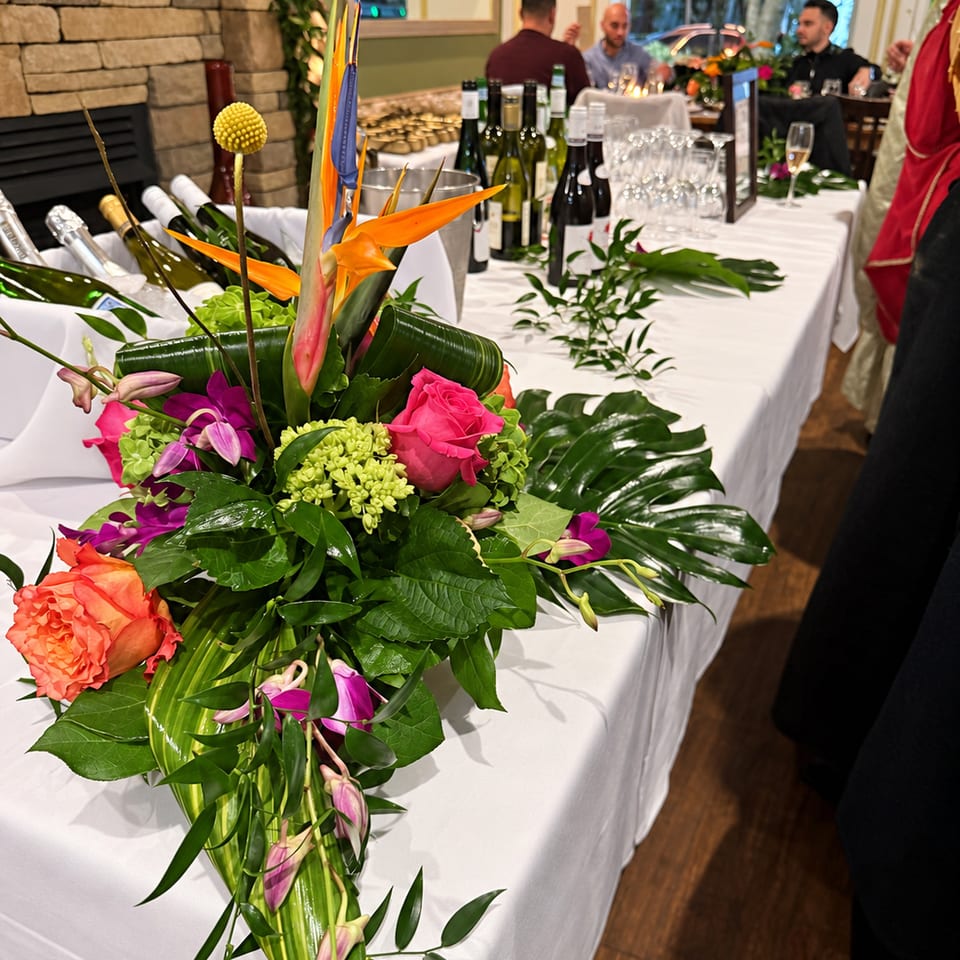 Floral arrangement beside an event drinks table