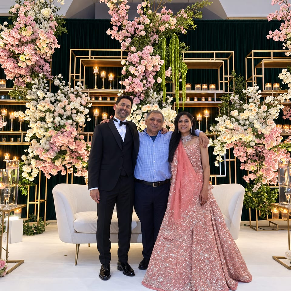 Wedding guests posing before a pink floral backdrop